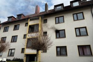 Feuerwehr löscht Küchenbrand in Bremerhaven; Rauch dringt aus Wohnung, Bewohner evakuiert.