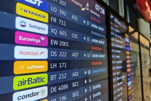 Piloten streiken vor Flughafen, Passagiere warten verzweifelt auf Informationen zu Flugstreichungen.
