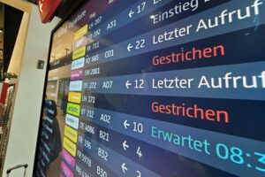 Symbolische Darstellung eines Lufthansa-Pilotenstreiks: leere Gates, gestrichene Flüge, frustrierte Passagiere und Warnschilder.