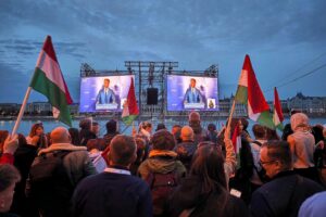 Péter Magyar lächelt optimistisch, umgeben von Wahlunterlagen und Unterstützern in Budapest.