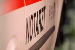Pedelec-Fahrer und Auto kollidieren; Notarzt und Polizei am Unfallort in Wuppertal.