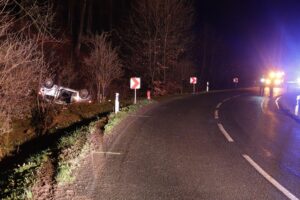 Schwerer Verkehrsunfall mit einem umgestürzten Auto und Einsatz von Rettungskräften.