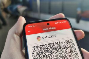 Eine Menschenmenge an einer U-Bahn-Station mit Deutschlandtickets in der Hand, urbanes Verkehrsbild.