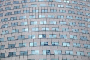 Glasfassade eines modernen Bürohauses, symbolisiert wirtschaftliche Entwicklung und Arbeitsplatzbedingungen in Nordrhein-Westfalen.