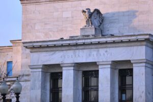 Symbolbild der Federal Reserve mit Grafiken zu Leitzins und wirtschaftlichen Trends.