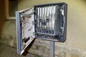 Zigarettenautomat in einer Straße, umgeben von Polizeiabsperrung nach Explosion und Diebstahl.