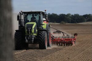 Bauer mit Traktor auf dem Feld, symbolisiert moderne Landwirtschaft und Unternehmensgruppen in Deutschland.