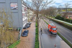 Wasserrohrbruch in Baden-Baden mit strömendem Wasser und abgesperrter Straße. Rettungsmaßnahmen im Gange.