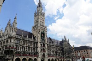 Sonniges Wetter über dem Neuen Rathaus in München, klare Sicht, leicht bewölkter Himmel.