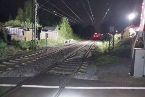 Bahnübergang mit abgelegtem Anhänger, Zugsicherung, Polizei, Unfallstelle, und gefährlicher Eingriff ins Bahnsystem.