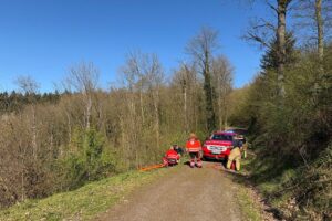 Rettungskräfte sichern Hang, um ältere Spaziergänger aus steilem Gelände zu retten.