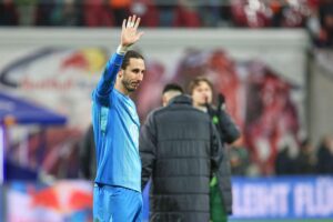 Zwei Fußballspieler beim Kopfball, Zuschauer jubeln, Spielstand 1:1 in intensiver Bundesliga-Partie.