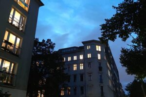 Eine gemütliche Wohnung mit einer einsamen Person, Licht, Bücher und persönliche Gegenstände sichtbar.