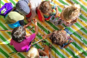 Buntes Spielmobilfeier mit Kindern, Hüpfburg, Kreativangeboten und fröhlicher Gemeinschaftsschaffung.