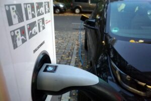 Elektroauto lädt an einer Ladesäule, symbolisiert die unzureichende Ladeinfrastruktur in Deutschland.