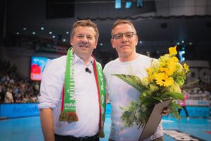 Ministerpräsident überreicht Verdienstorden an Alfred Gislason im Rahmen eines Handballspiels.