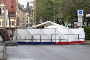Auto breitet sich bedrohlich in Menschenmenge aus, symbolisiert Amokfahrt und tragisches Unglück.