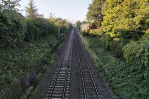 Zweigleisige Bahnstrecke mit modernen Zügen, symbolisiert Wettbewerb und Unsicherheit im Fernverkehrsmarkt.
