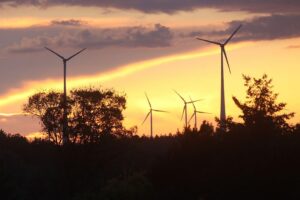 Windräder auf grüner Wiese, Symbol für erneuerbare Energien und Rückgang des Primärenergieverbrauchs in Deutschland.