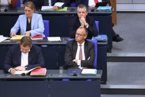 Joe Kaeser diskutiert Minderheitsregierung; Merz und andere Politiker als zentrale Akteure abgebildet.