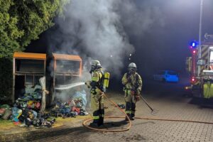 Brennende Altkleidercontainer in der Nacht, Feuerwehr im Einsatz, dramatische Rettungsaktion dargestellt.