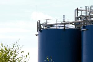 Öltanks vor einem dramatischen Hintergrund, symbolisieren die steigenden Energiepreise und globale Konflikte.