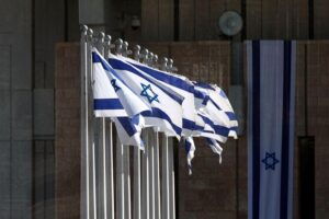 Israelische Fahnen, symbolisierende Konflikte und politische Spannungen im Nahen Osten und EU-Sanktionen.