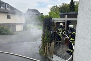 Heckenbrand in Ense-Lüttringen: Feuerwehr im Einsatz zur Kontrolle und Nachlöscharbeiten.