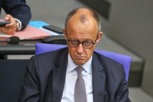 Friedrich Merz in Berlin, umgeben von Politikern, symbolisiert die aktuelle politische Diskussion und Führungskrise.