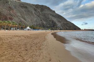 Weißer Sandstrand Teneriffas mit Sicherheitsmaßnahmen für Kreuzfahrtschiff aufgrund Hantavirus-Ausbruch.