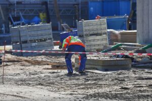 Baustelle mit Bauarbeitern, die dringend benötigte Wohnungen symbolisieren, in einem urbanen Umfeld.