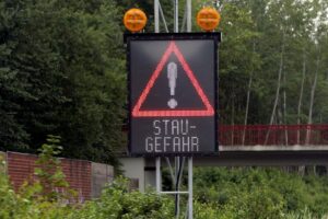 Stau auf Autobahn mit Baustellen, starkem Verkehr und frustrierte Autofahrer im Berufsverkehr.