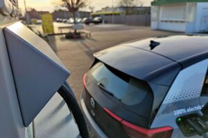 E-Auto-Ladestation mit Elektrofahrzeugen vor modernem Hintergrund, symbolisiert nachhaltige Mobilität und Förderung.