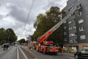 Feuerwehr rettet Person aus verrauchter Wohnung, Einsatzkräfte bei der Arbeit, Hochleistungslüfter im Einsatz.