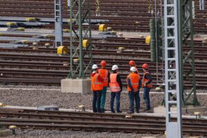 Arbeiter bei der Gleisanlage, symbolisch für steigende Löhne und Wirtschaftswachstum in Deutschland.