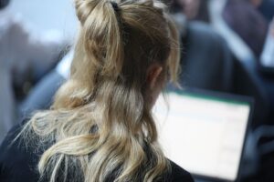 Junge Frau mit Laptop symbolisiert Entgelttransparenz und Chancengleichheit für Frauen im Arbeitsmarkt.