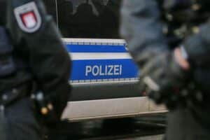 Ein Polizei-Einsatzfahrzeug vor einem beschoßenen Gebäude in Berlin, um Ermittlungen einzuleiten.