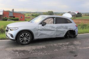 Unfallfahrzeug auf Landstraße, Polizei und Rettungsdienst vor Ort, schwer verletzter Fahrer.