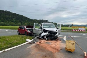 Zwei beschädigte Fahrzeuge nach schwerem Verkehrsunfall, Polizeiabsperrung, Rettungsdienste vor Ort.
