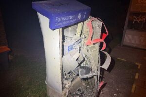 Zerstörter Fahrkartenautomat nach Explosion, Polizei ermittelt, Tatort mit Schäden und Sicherheitsmaßnahmen.