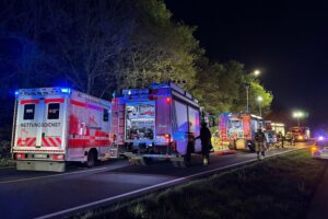 Schwerer Verkehrsunfall: Unfallwagen, Feuerwehrkräfte bei Rettungsarbeiten, Unfallstelle abgesperrt.