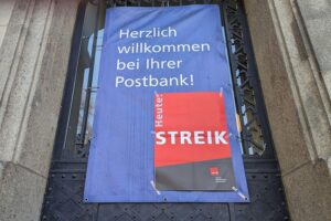Postbank-Filiale mit Streik-Hinweis; Warnstreiks für bessere Gehälter und Beschäftigungssicherung angedroht.