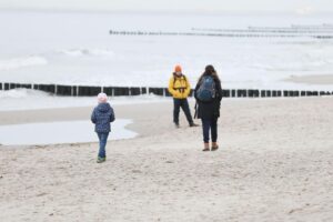 Familien am Strand, glückliche Eltern mit Kindern, symbolisieren die Wichtigkeit des Elterngeldes.
