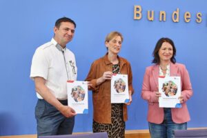 Bild zeigt Bundesfamilienministerin und Experten bei der Präsentation des Kinderreport 2026 in Berlin.