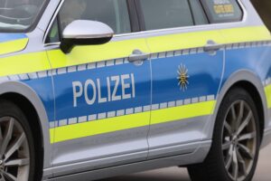 Polizeiauto vor Mehrfamilienhaus, Ermittlungen nach tödlichem Streit, Zeugen gesucht.