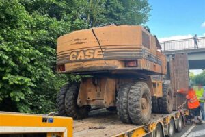 Bagger mit Totalschaden nach Brückenunfall; Tieflader beschädigt, kein Verletzter.