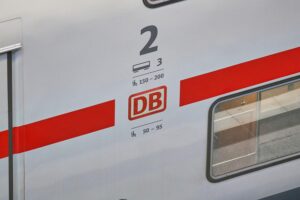 Ein Zug der Deutschen Bahn unter blauem Himmel, symbolisiert Pünktlichkeit und Fahrgastkomfort.