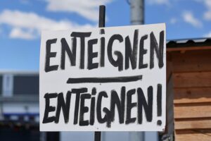 Ein Schild mit "Enteignen" symbolisiert die Debatte um Wohnraummangel in Berlin.