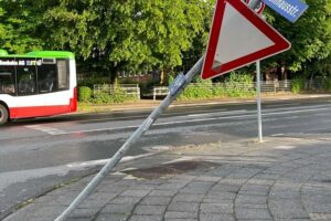 Unfallstelle mit beschädigten Verkehrsschildern, Polizei vor Ort, betrunkenen Autofahrer.
