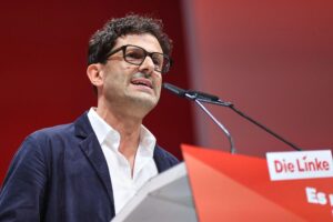 Luigi Pantisano vor einem politischen Hintergrund, symbolisiert Konflikt zwischen CDU und Linker.